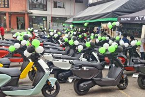 A massive lineup of colorful Ather 450X and Ather Rizta electric scooters parked outside a decorated Vaidya Energy delivery venue in Kathmandu.