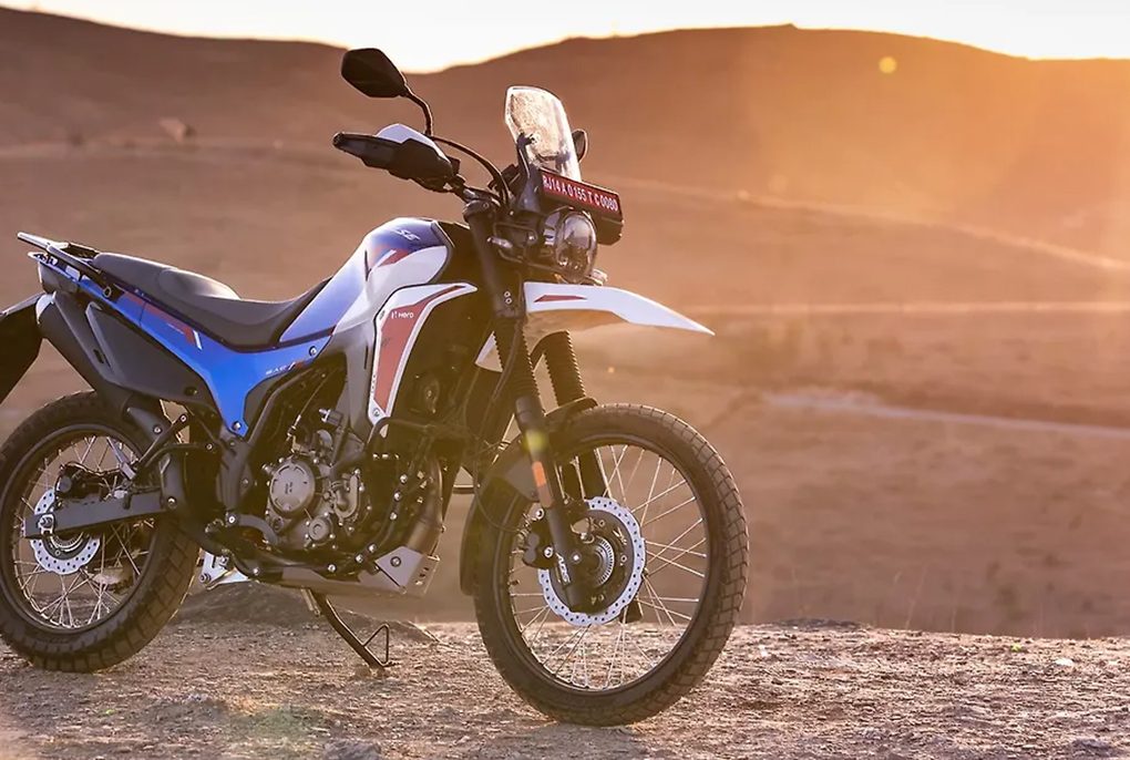 The rugged Hero Xpulse 210 adventure motorcycle showing off its tall windscreen and high-mounted front fender on a dirt trail
