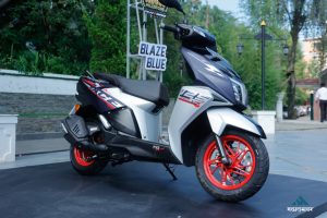 The sporty front fascia of the TVS Ntorq 125 Race XP Blaze Blue scooter featuring sharp LED headlamps and signature red alloy wheels.