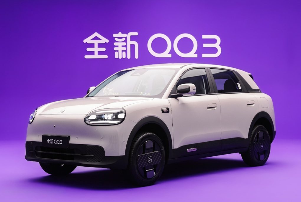 Front three-quarter angle of the new mint green Chery Q electric urban crossover featuring a closed-off grille and futuristic LED daytime running lights.