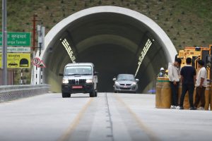 The brightly lit interior of the dual-lane Nagdhunga-Sisnekhola road tunnel showing modern jet fan ventilation systems on the roof.