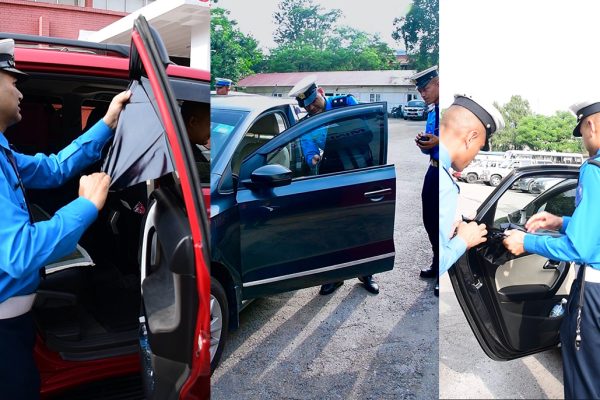 Traffic police removing illegal black tints from the official government vehicle of the Home Minister.